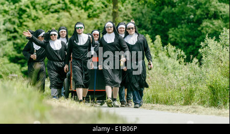 Timmerhorn, Allemagne. 29 mai, 2014. Les jeunes hommes en costumes nun mars une longue route entre un pays et Timmerhorn Bargteheide, Allemagne, 29 mai 2014. Le groupe se réunit chaque année le jour de l'Ascension pour célébrer la traditionnelle Fête des Pères. Photo : MARKUS SCHOLZ/apd /Alamy Live News Banque D'Images