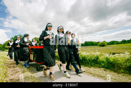 Timmerhorn, Allemagne. 29 mai, 2014. Les jeunes hommes en costumes nun mars une longue route entre un pays et Timmerhorn Bargteheide, Allemagne, 29 mai 2014. Le groupe se réunit chaque année le jour de l'Ascension pour célébrer la traditionnelle Fête des Pères. Photo : MARKUS SCHOLZ/apd /Alamy Live News Banque D'Images