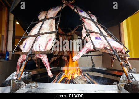 Asado argentin agneau entier plus de grillage de feu ouverts dans la fenêtre Ushuaia Argentine restaurant Banque D'Images