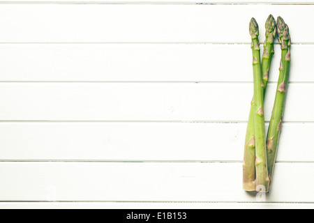 Asperges vertes sur table en bois blanc Banque D'Images