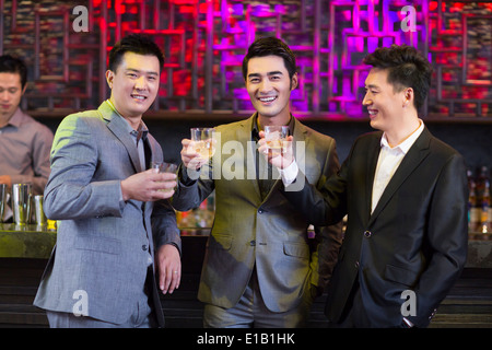 Young Friends toasting at bar Banque D'Images