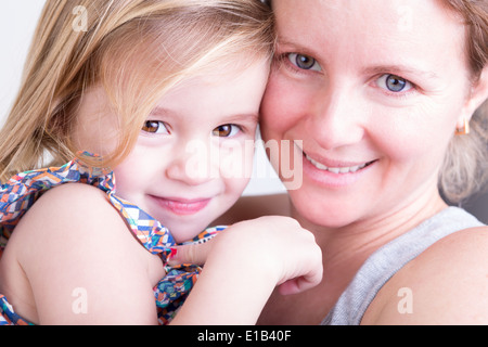 Close up portrait du visage d'un sourire heureux belle petite fille avec sa mère à l'appareil photo à partager un moment de tendresse Banque D'Images