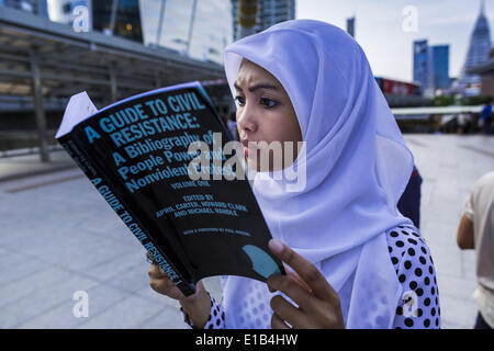 Bangkok, Bangkok, Thaïlande. 29 mai, 2014. Une femme lit ''Guide de la résistance civile'' au cours d'une manifestation contre le coup d'Etat thaïlandais jeudi. Environ huit personnes se sont réunies à l'intersection Chong Nonsi silencieusement à Bangkok à lire George Orwell's ''1984'' et d'autres livres sur la désobéissance civile. Les protestations sont basées sur le ''Sstanding Man'' des protestations qui ont commencé en Turquie l'été dernier. Compétentes n'a fait aucun effort pour arrêter la protestation ou interférer avec les gens qui étaient la lecture. Crédit : Jack Kurtz/ZUMAPRESS.com/Alamy Live News Banque D'Images