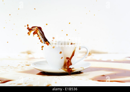 Tasse de café renverser de créer de belles splash avec taches sur le blanc. Pause-café, le petit-déjeuner gratuit. Banque D'Images