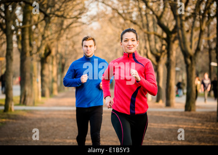 Couple jogging - jeune homme et femme de la compétition, première femme Banque D'Images