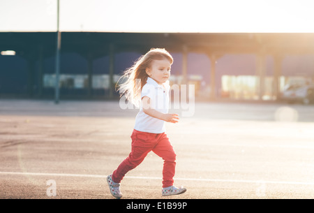 Petite fille en fuite sur la route Banque D'Images