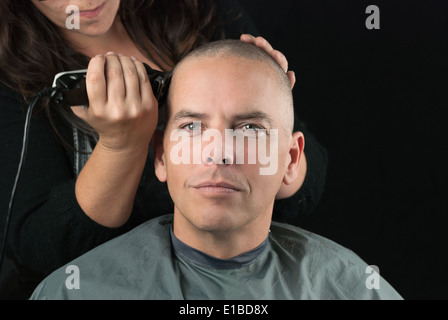 Close-up d'un coiffeur utilisant clippers à raser la tête des clients. Banque D'Images