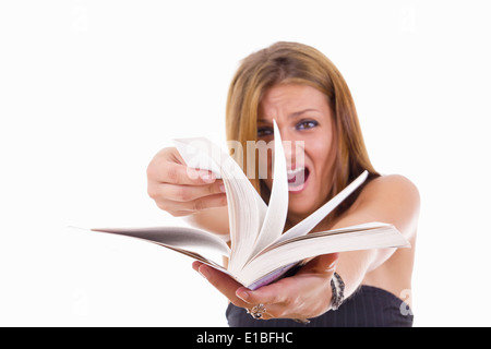 Angry female student basculant un livre, studio isolé sur fond blanc Banque D'Images