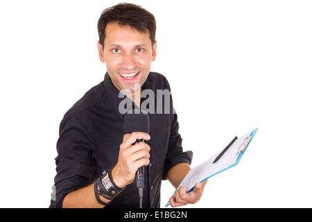 Beau mâle journaliste diffusant des nouvelles sur les notes en main avec microphone Banque D'Images