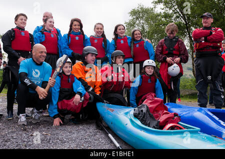 Gwynedd, Pays de Galles, Royaume-Uni. 29 mai, 2014. Monsieur Dave Brailsford (à gauche, avec la Baton) et les jeunes de Gwynedd célébrer l'arrivée du Queen's baton à Padarn Country Park, Gwynedd, dans le cadre de son relais voyage autour du Pays de Galles, avant l'ouverture des Jeux du Commonwealth à Glasgow. L'équipe de canoë pagayé à travers Lyn Padarn à battre le lac Train dans une course. Crédit : Michael Gibson/Alamy Live News Banque D'Images