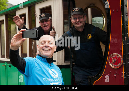 Gwynedd, Pays de Galles, Royaume-Uni. 29 mai, 2014. Monsieur Dave Brailsford (à gauche) prend un '70623' en face de l'Llanberis Lake Railway moteur, à la fin de la course entre Llyn Padarn et kayakistes sur le train qui longe le lac. Dans le cadre de son relais voyage autour du Pays de Galles, avant l'ouverture des Jeux du Commonwealth à Glasgow, l'équipe de canoë pagayé à travers Lyn Padarn à battre le lac train dans la course. Crédit : Michael Gibson/Alamy Live News Banque D'Images