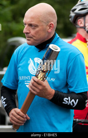 Gwynedd, Pays de Galles, Royaume-Uni. 29 mai, 2014. Le Queen's baton tenu par Monsieur Dave Brailsford après qu'il avait monté avec elle par location de Caernarfon, dans le cadre de son relais voyage autour du Pays de Galles, avant l'ouverture des Jeux du Commonwealth à Glasgow Crédit : Michael Gibson/Alamy Live News Banque D'Images