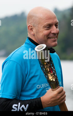 Gwynedd, Pays de Galles, Royaume-Uni. 29 mai, 2014. Le Queen's baton tenu par Monsieur Dave Brailsford par lac Padarn après qu'il avait monté avec elle par location de Caernarfon, dans le cadre de son relais voyage autour du Pays de Galles, avant l'ouverture des Jeux du Commonwealth à Glasgow Crédit : Michael Gibson/Alamy Live News Banque D'Images