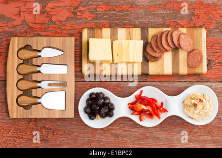 Vue de dessus d'une sélection de plats salés, bouchées sur une table en bois rustique avec fromage Havarti, saucisse épicée, olive Banque D'Images