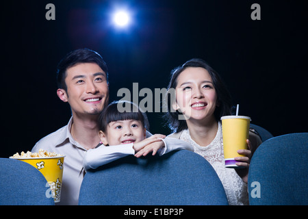 Jeune famille regarder la vidéo dans le cinéma Banque D'Images