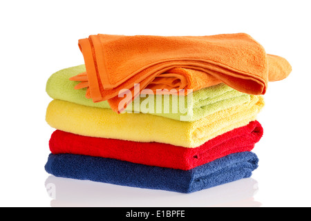 Soigneusement pliés pile de serviettes moelleuses doux dans les couleurs de l'arc-en-ciel sur un fond blanc avec le haut orange towe Banque D'Images