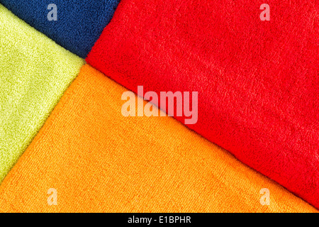 Texture de fond coloré de serviettes en coton disposés en diagonale un motif géométrique ou rouge, orange, jaune et bleu Banque D'Images