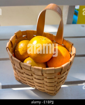 Les oranges dans le panier sur la chaise blanche. Banque D'Images