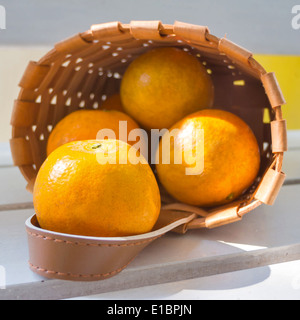 Les oranges dans le panier sur la chaise blanche. Banque D'Images