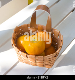 Les oranges dans le panier sur la chaise blanche. Banque D'Images