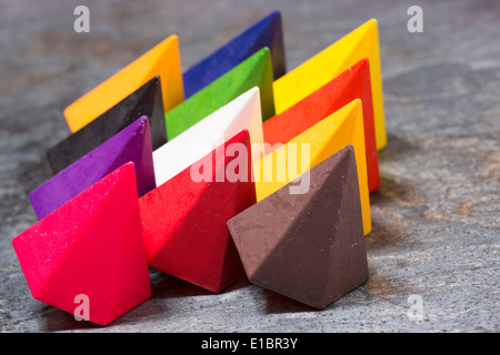 En forme de losanges multicolores dynamiques les crayons de cire aux couleurs de l'arc en ciel disposés en trois rangées sur un fond noir en gris, Banque D'Images