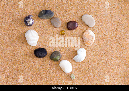 Coeur romantique au bord de la mer, sur la plage de sable doré formé de roches et de coquilles brisées représentant une Saint Valentin ou anniversaire w Banque D'Images