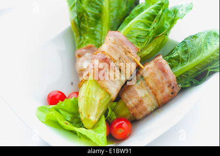 Cos vert enrobé de bacon sur le plat blanc Banque D'Images