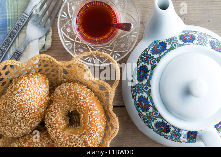 Close up Vue de dessus d'or croustillant Sésame turque bagels frais servi avec une tasse de thé fraîchement infusé et une théière pour t Banque D'Images