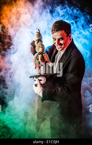 Un sinistre mal mauvais magicien nimbées d'un enfant tirant fumée Doudou lapin d'un chapeau haut de forme Banque D'Images