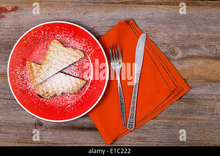 Panini italien traditionnel avec de la confiture de bleuets saupoudrée de sucre en poudre et servi sur une plaque orange colorée avec un matchin Banque D'Images