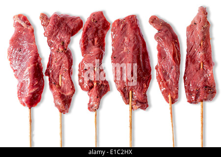 Ligne de brochettes de boeuf avec l'adjudication de la viande maigre filetées sur bois Prêt pour griller sur un barbecue d'été isolated on white Banque D'Images