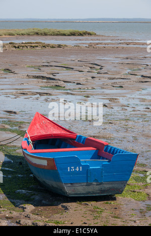 Un petit bateau de pêche en bois peint échoué sur les rives de l'estuaire du Sado en dehors de Carracqueira village sur l'Algarve. Banque D'Images