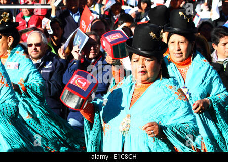 La Paz, Bolivie. 30 mai 2014. Les danseurs Cholita vêtus de robe traditionnelle tiennent des hochets sous la forme d'une cabine de téléphérique / gondole tout en dansant la morenada lors de la cérémonie d'inauguration du système de téléphérique de la ligne Rouge reliant la Paz et El Alto. Crédit : James Brunker / Alamy Live News Banque D'Images