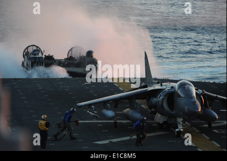 Le personnel du ministère de l'air U.S. Navy Marine Corps approche un AV-8B Harrier avion pendant qu'un des engins de débarquement, d'un coussin d'air attaché t Banque D'Images