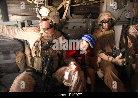 Les Marines américains, SSgt. Jeff Liddic LCpl (à gauche) et. Thelonious Riddick (droite), escort Hayatullah, un jeune Afghan de 7 ans, ba Banque D'Images