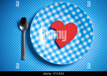 Valentine heart shape partiellement mangés sur une plaque, affamé pour love concept Banque D'Images
