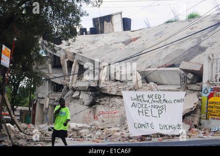 Un Haïtien passe devant un panneau qui demande de l'aide et des fournitures à Port-au-Prince, Haïti, 19 janvier 2010. De toutes les directions d'unités o Banque D'Images