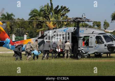 Les soldats de l'armée des États-Unis et d'Haïti les membres de charger des patients médicaux à bord d'un marine de l'hélicoptère MH-60S Knighthawk 21 janvier 2010, Banque D'Images