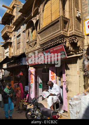 L'Inde, Rajasthan, Jaisalmer, Textile bazar, Man reading newspaper in shop door Banque D'Images