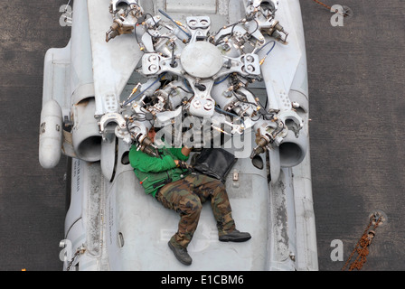 L'aviation de la Marine américaine du machiniste Mate Airman Felix Carcamo remplace l'élément de chauffage arrêt statisme sur un SH-60F Seahawk helicopte Banque D'Images