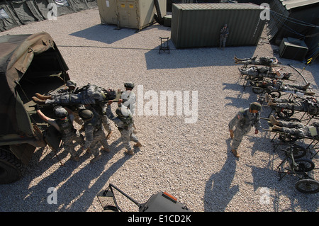 Des soldats américains de la 344e de l'Hôpital de soutien au combat hors de Fort Dix, N.J., chargez un patient simulé dans un véhicule au cours Inscrivez-vous Banque D'Images