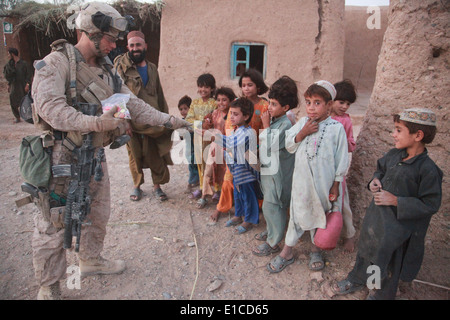 L'Hôpital de la Marine américaine 3e classe Corpsman Brandon Sills mains des bonbons aux enfants dans la province de Helmand en Afghanistan le 25 août Banque D'Images