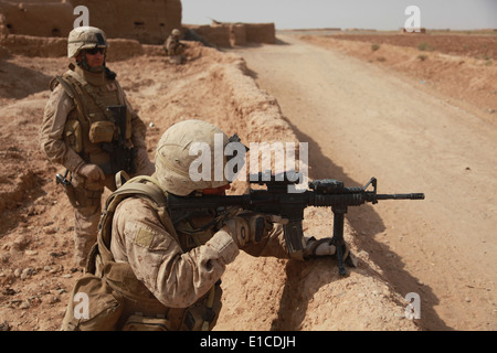 U.S. Marine Corps Capts. Althiser au Tchad, avant-plan, et Chris McArthur scanner leurs repas lors d'une patrouille avec bras nationale Afghane Banque D'Images