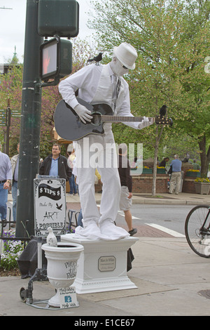 Asheville, Caroline du Nord, USA - Le 26 avril 2013 : "l'homme en blanc' une statue vivante pose et joue de la guitare pour obtenir des conseils sur la rue Banque D'Images