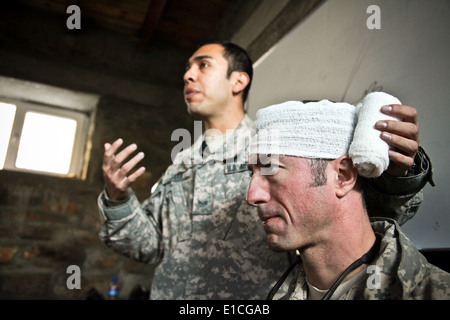 U.S. Air Force Capitaine John Stamm simule une personne ayant une blessure à la tête alors que le s.. Abraham Jara explique la bonne procedu Banque D'Images