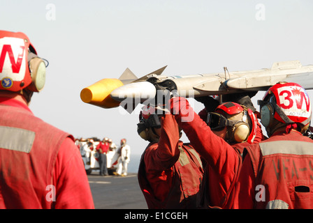 L'aviation de la Marine américaine ordnancemen affecté à la "grève" des Warhawks Fighter Squadron 97 charger explosées sur un F/A-18C Hornet ai Banque D'Images