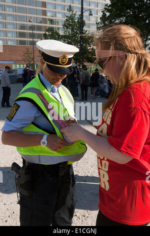 Copenhague, Danemark. 30 mai 2014. Militante (à droite), pour protester contre la réunion du Bilderberg à la Copenhagen Marriott Hotel, met un autocollant sur une police woman's uniforme (à gauche). L'étiquette indique "l'amour". La police woman (à gauche) est partie d'une importante unité de police - ce que l'on appelle un "dialogue" - placé dans autour de la démonstration de militants. Credit : OJPHOTOS/Alamy Live News Banque D'Images