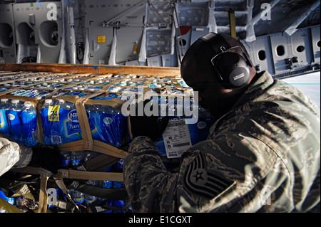 Le sergent de l'US Air Force. Douglas Hicks pousse une palette d'eau sur un U.S. Air Force C-17 Globemaster III dirigé à Banque D'Images