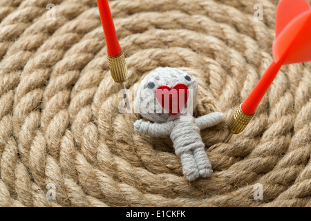 Valentine toy fabriqué à partir de fil blanc avec un coeur au lieu de bouche , sur un fond corde Banque D'Images