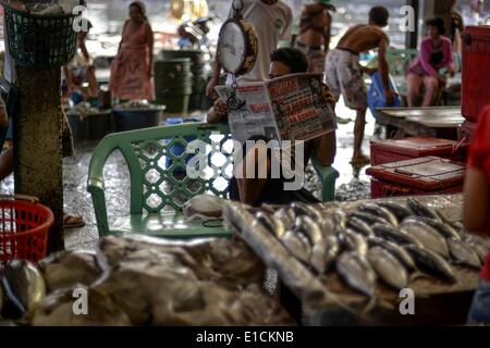 Paranaque, Philippines. 31 mai, 2014. Un vendeur de poisson lit un journal lors de l'attente pour les clients dans un petit marché de poisson de Paranaque, au sud de Manille, Philippines, le 31 mai 2014. Les petits pêcheurs dans le pays ont fait pression sur le gouvernement local à l'état de l'adresse d'ozone ressources côtières en raison d'un manque d'entretien et le changement climatique, et l'absence de lois visant à empêcher la surpêche et l'exploitation.Photo : Ezra Acayan/NurPhoto Acayan Crédit : Ezra/NurPhoto ZUMAPRESS.com/Alamy/Live News Banque D'Images